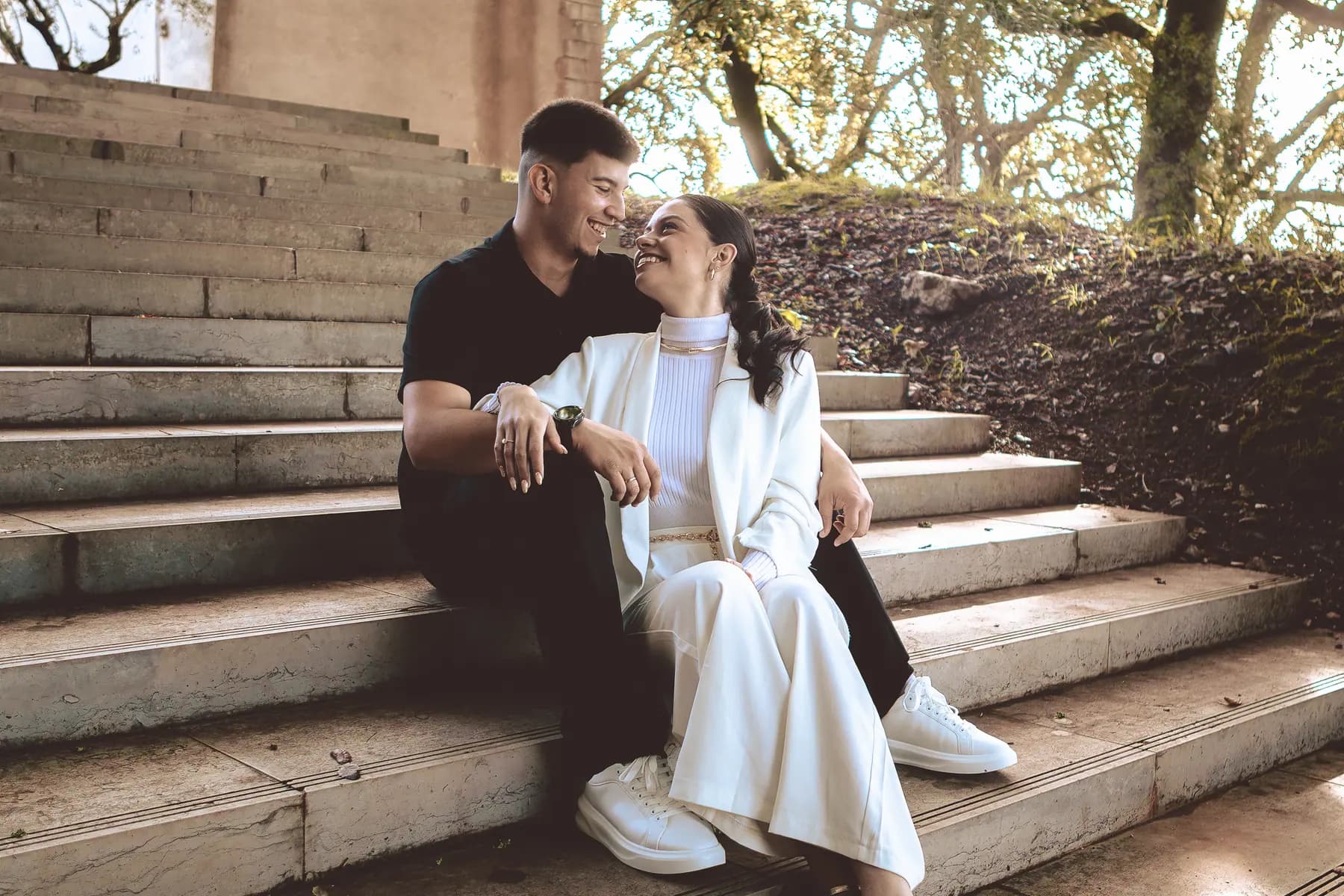Casal sentado numa escadaria durante uma sessão fotográfica