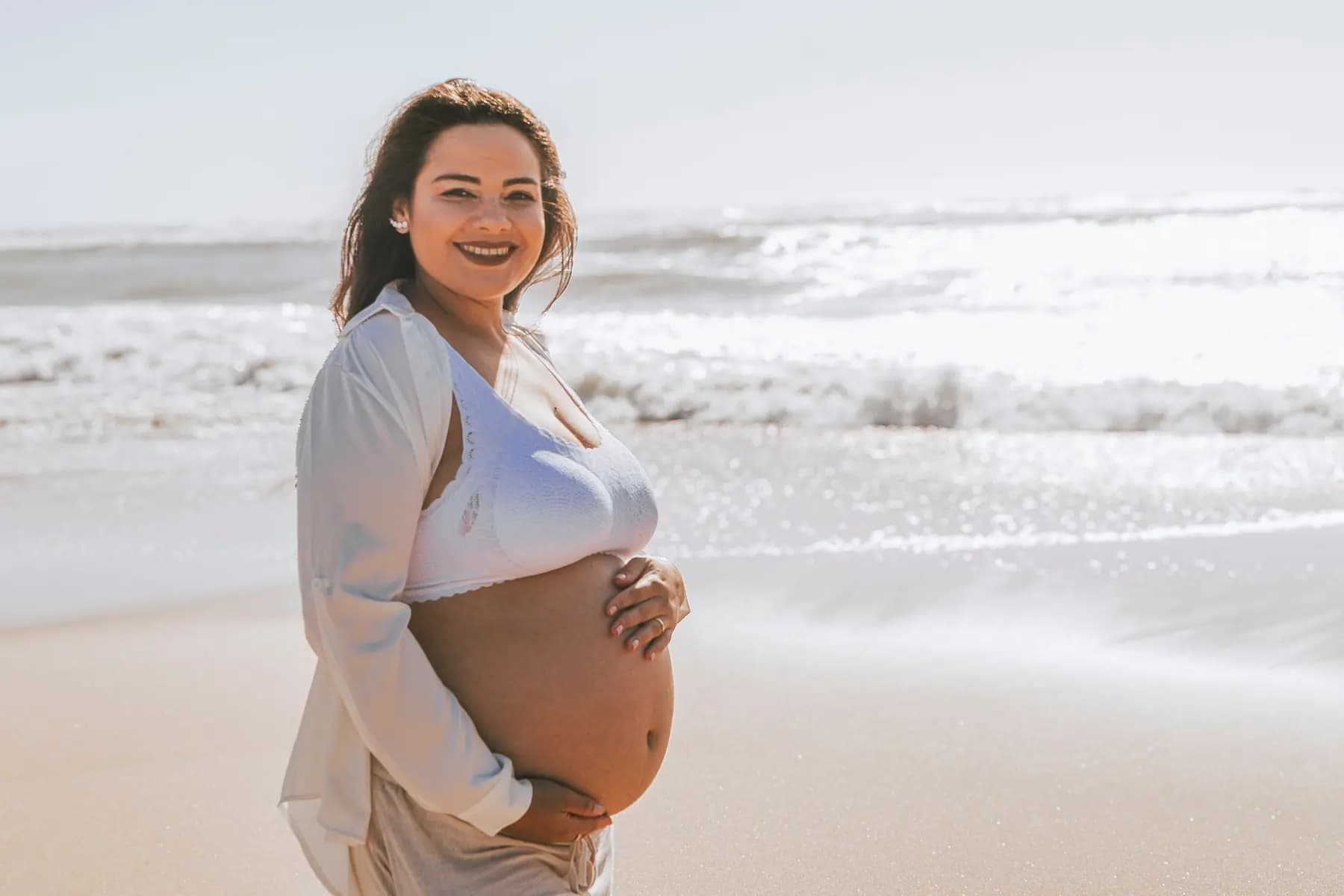 Grávida junto ao mar numa sessão de maternidade