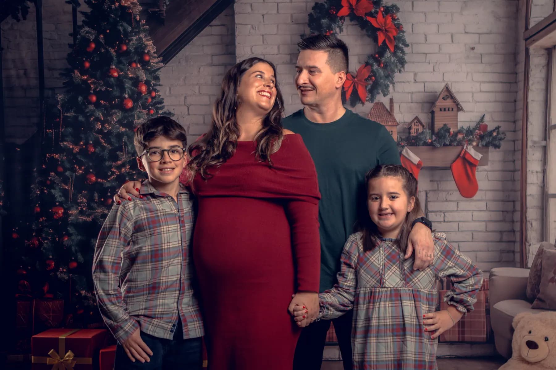 Família à volta da árvore de Natal, numa sessão em estúdio